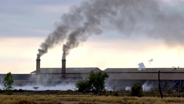  industry and pollution concept, 4K Footage of Smokestack Factory at the countryside at evening time, zoom in effect, industry and pollution
