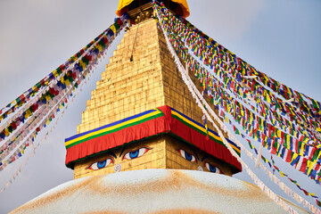 Boudhanath stupa in Kathmandu, Nepal decorated Buddha wisdom eyes and prayer flags, most popular tourist attractions in Kathmandu reflecting harmonious blend of spirituality and tourism - obrazy, fototapety, plakaty