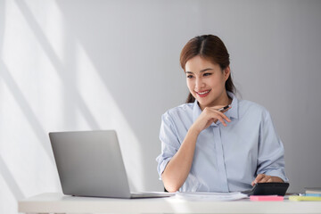 Happy middle-aged businesswoman working in the office. Businesswoman working on laptop and using in remote online job interview meeting on laptop.