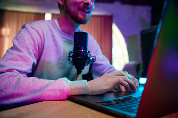 Cropped image of smiling young man, blogger making online podcast show, giving interview,...