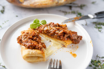 Pancake filled with mozzarella cheese and bolognese sauce topping on a plate