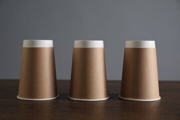 Shell game. Three paper cups on wooden table