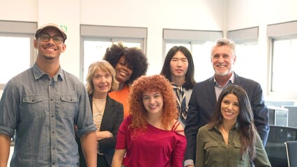 group of smiling multiracial office mates looking at the camera