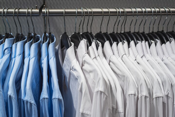 Blue and white shirts on hangers hanging on the rack