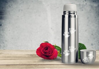 Remembrance of a domestic pet. steel urn and red rose.