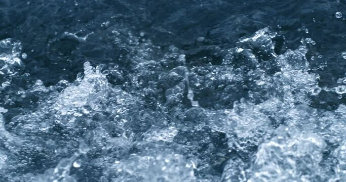 Super slow motion macro of powerful river flowing stream of cold fresh pure water crushing waves with splashing drops perfect for extreme sports as kayak rafting, filmed at 1000 fps.