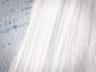 Beautiful winter background with snowy ground. Natural snow texture. Wind sculpted patterns on snow surface.