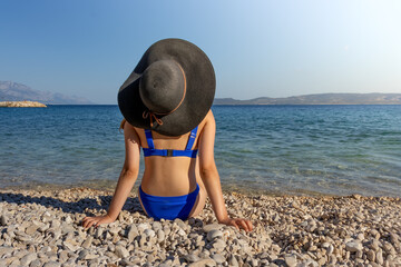 Resting girl in a hat on the beach. Selective focus