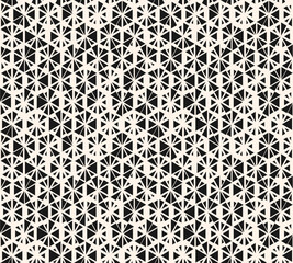Monochrome vector seamless pattern with small randomly scattered triangles, floral shapes, hexagonal grid. Black and white modern texture. Stylish background with halftone effect. Trendy geo design