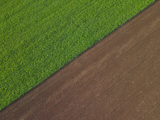 Aerial view of a farmland with grass and soil in the countryside