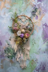 beautiful dreamcatcher made of macrame and dry flowers on a green purple background