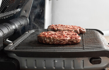 Juicy beef patty for burgers on a hot grill