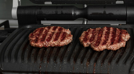 Beef cutlets for hamburger on grill. Preparing burgers at home