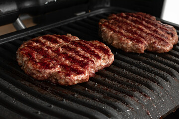 Freshly grilled burger meat. Burgers on the grill. Cooking burgers on hot grill