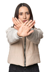 Modern young Caucasian woman portrait on studio background doing a denial gesture