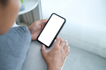 Closeup man using mobile phone while lying on couch. White empty screen for your advertising.