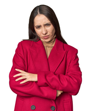 Modern young Caucasian woman portrait on studio background unhappy looking in camera with sarcastic expression.
