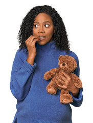 Expecting African American with teddy bear biting fingernails, nervous and very anxious.