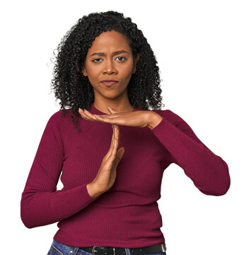 African American woman in studio setting showing a timeout gesture.