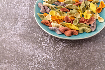 Colorful pasta background. Top view of five colors pasta shells .Heap of colorful spiral...