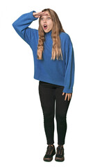 Studio portrait of a blonde Caucasian woman looking far away keeping hand on forehead.