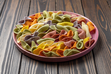 Colorful pasta background. Top view of five colors pasta shells .Heap of colorful spiral pasta,macaroni texture.