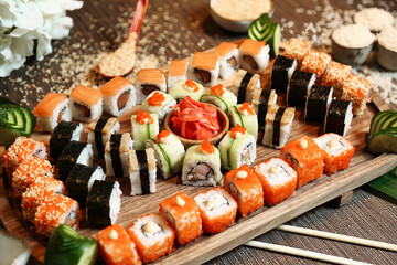 Wooden Tray Covered in a Variety of Sushi Rolls