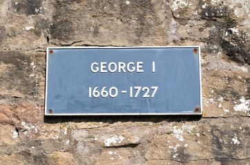 Metal Sign 'George I 1660-1727' on Old Rough Stone Wall 
