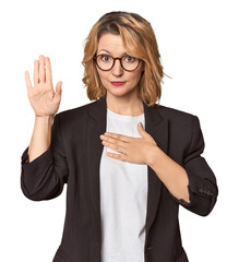 Caucasian woman in black business suit taking an oath, putting hand on chest.