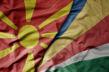 big waving national colorful flag of seychelles and national flag of macedonia .