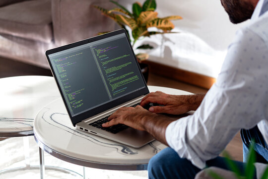 Developer programmer writing html javascript code in a laptop.