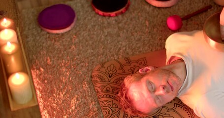 Singing Bowls and Candlelight: Inner Harmony Healing Session in action. Sound therapy with Singing bowls used to create harmonious sound vibrations that affect psychophysiological state of person.