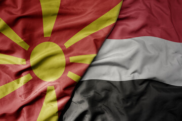 big waving national colorful flag of yemen and national flag of macedonia .