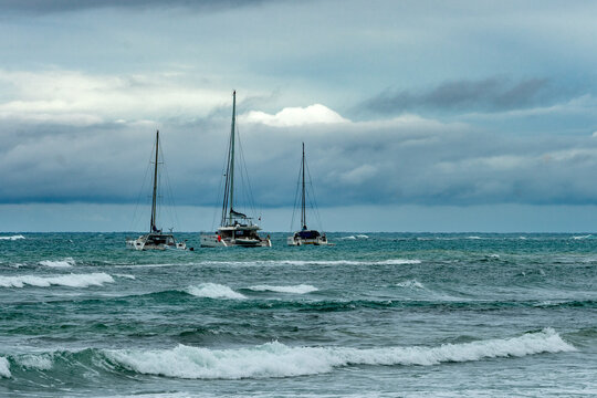 Dramatic image of sailboats in the Caribbean bay of Las Terrenas in the Dominican Republic with stormy skies and choppy waters 