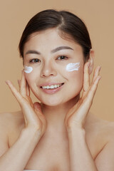 Portrait of young woman with facial cream on face