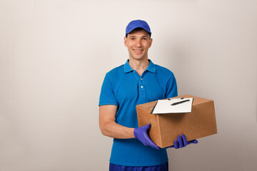 Fototapeta na wymiar Portrait of handsome attractive cheerful delivery man holding card-board box. Express delivery service. Copy space.