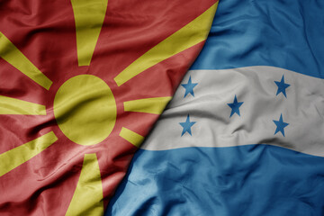 big waving national colorful flag of honduras and national flag of macedonia .