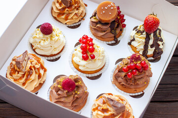 Vanilla, chocolate and peanut butter cupcakes with salted caramel, fresh raspberry, strawbeery and red currant in gift paper box