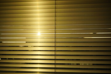 the sun is shining through the blinds of a window