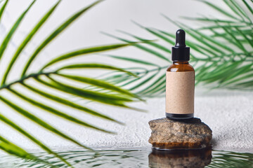 Beautiful shot of brown glass bottle with pipette and serum on natural background