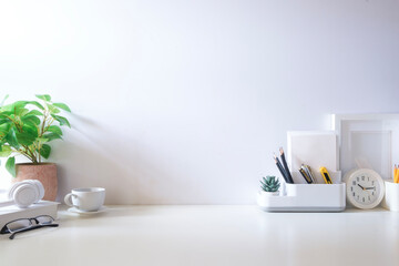 Minimal workspace with book, coffee cup and pencil holder on white table. Copy space for your...