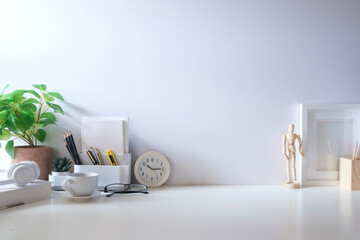 Minimal workspace with book, coffee cup and pencil holder on white table. Copy space for your...