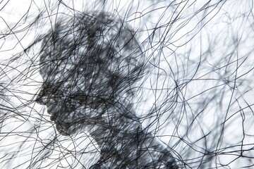 An abstract photograph of tangled, chaotic lines overlaid with a transparent silhouette depicting a person in a state of anxiety