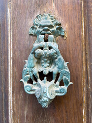 Closeup of a wooden door with a metal door knocker