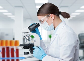 Female scientist using a microscope in office