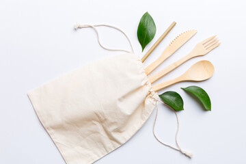 Eco friendly reusable recyclable white eco bag with kitchenware on Colored background. Concept zero...
