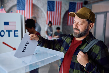 Smiling mature man voting during elections in USA.