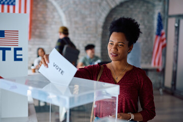 Black female citizen voting on US election day at the polling place.