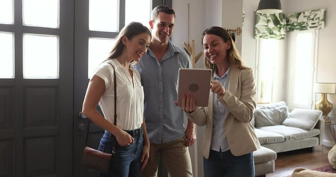Young couple listening offer of real-estate agent selling new-built property to spouses, after signing contract family receive keys feels happy with deal. First property, independence, bank mortgage