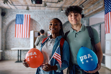 Young multiethnic couple voting during United States of America elections and looking at camera.